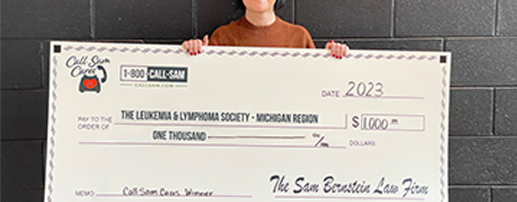 woman standing behind giant card board check