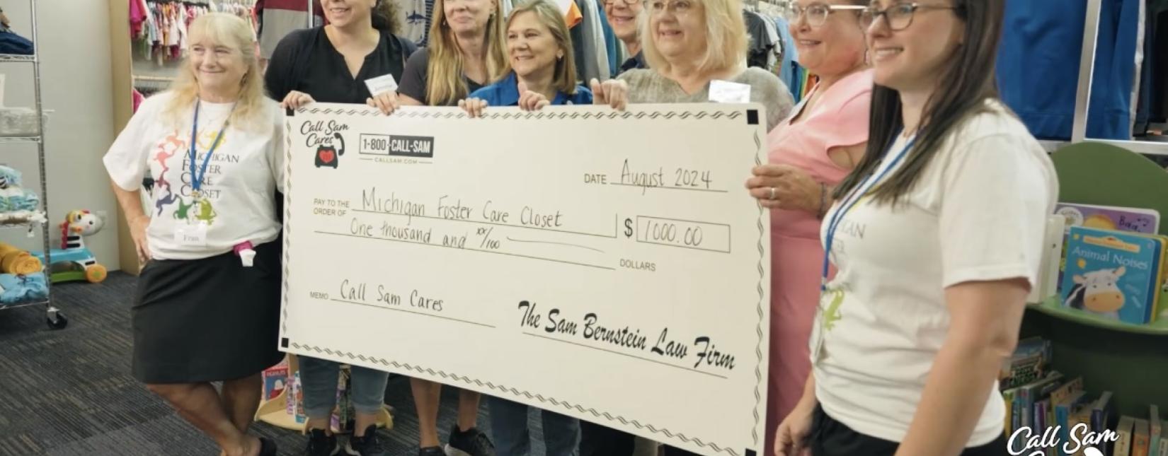 Group of ladies standing behind giant card board check