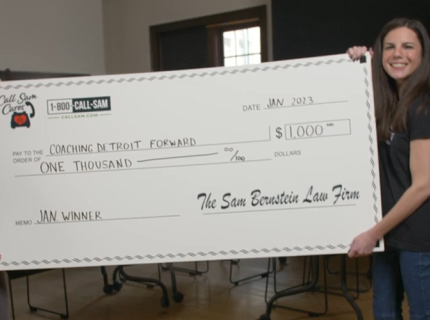 two people standing behind giant card board check