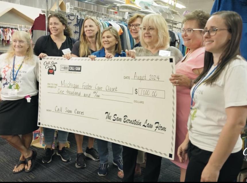 Group of ladies standing behind giant card board check